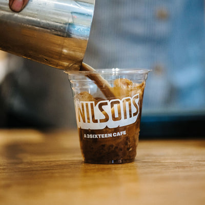 An espresso cocktail poured into a plastic cup with the Wilson's logo on it.
