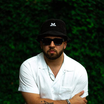 A man in a white shirt and black bucket hat.