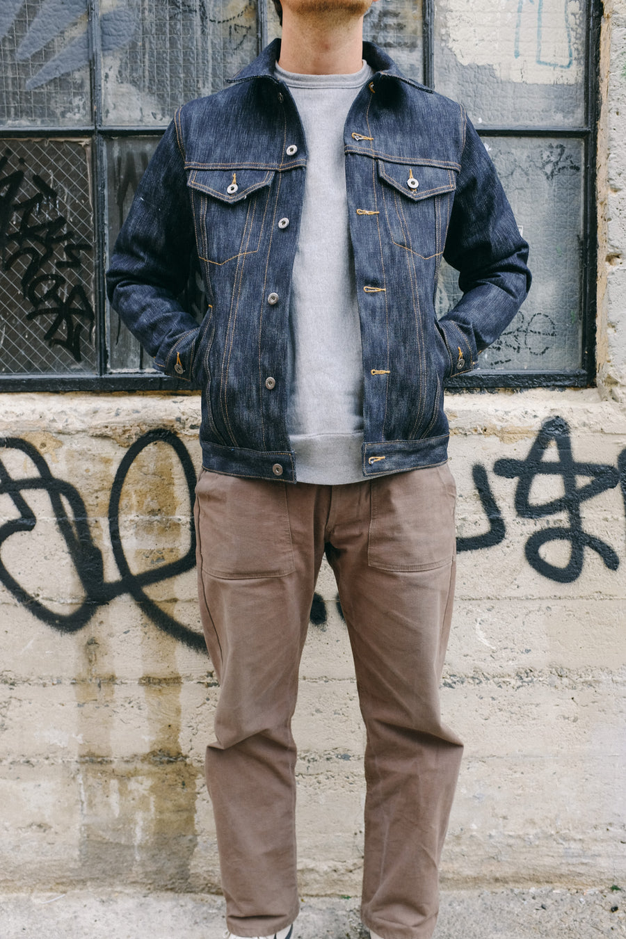 A model shows off the 3sixteen Type 3s jacket in 15y denim paired with olive fatigue pants.