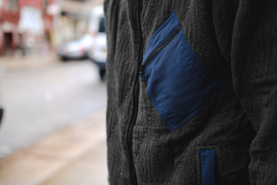 A close up shot of a black jacket worn on body.