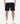 A pair of black soccer shorts with a relaxed fit, drawstring elastic waist, and hand stitching detail around the hem. Worn by a model with white sneakers.
