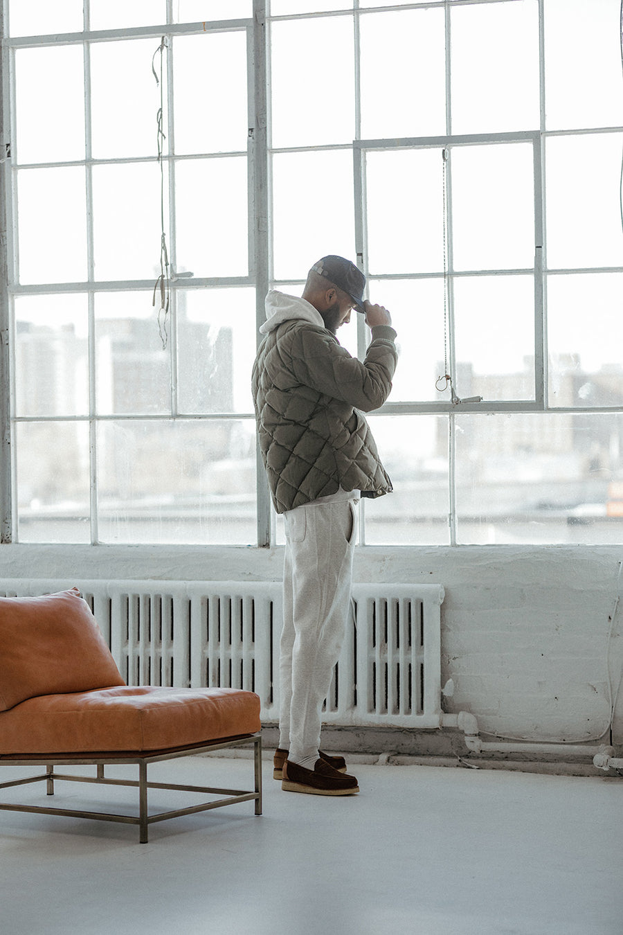 A man in a ball cap looks out a window.