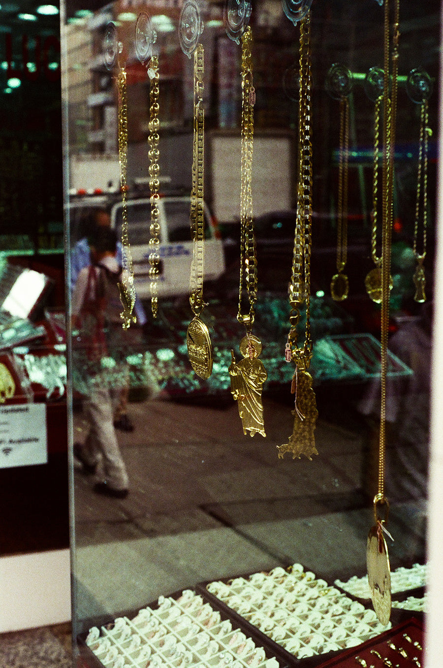 Gold chains hang in a window.