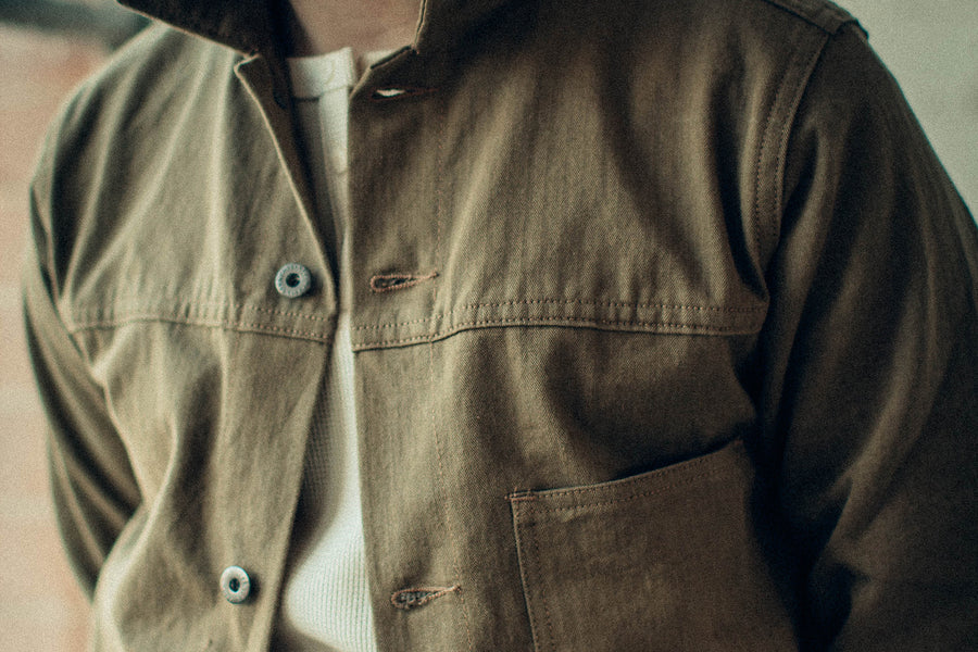 A closeup of a tan herringbone jacket.
