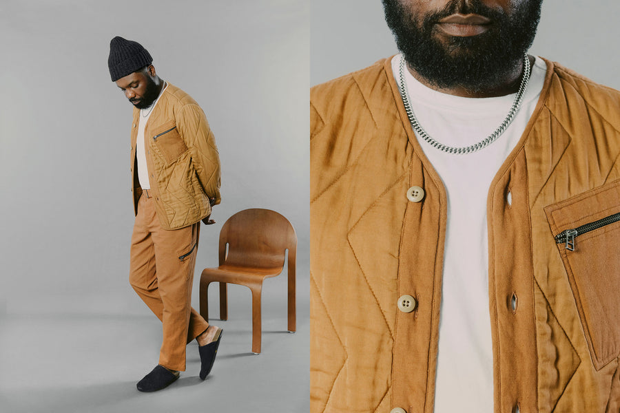 A man in a matching sienna set of jacket and pants walks across the screen.