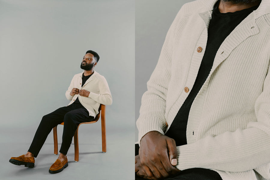 A man in a natural knit cardigan reclines in a chair.