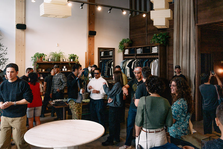 A crowd of people hang out and chat inside a retail store.