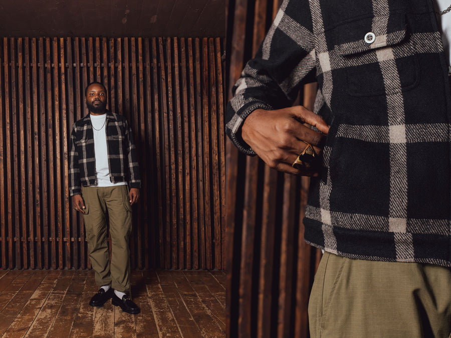 A man in a black plaid jacket and olive pants.