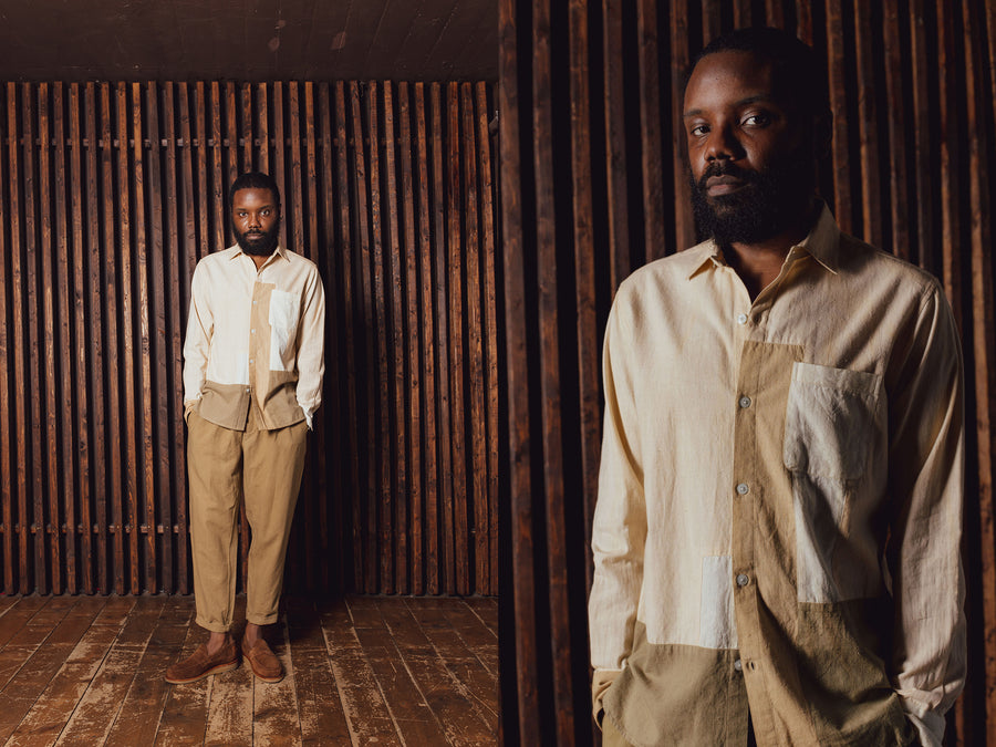 A man wears a patchworked tan shirt, tan pants and suede brown loafers.