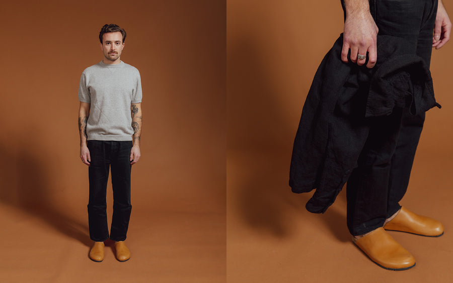 A man in a grey knit tee and black jeans