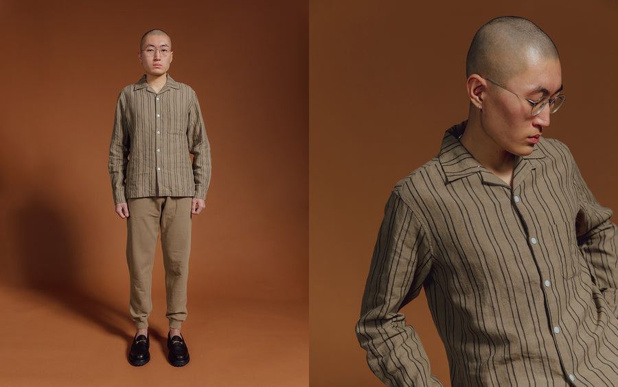 A man in an olive striped shirt and sweatpants.