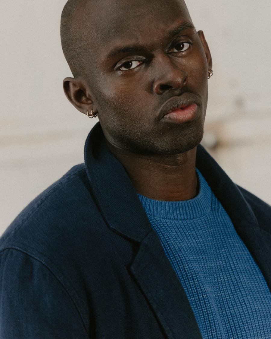A portrait of a man in a navy blazer.