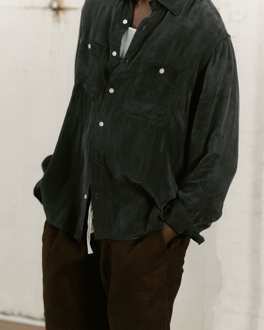 A close up shot of a flowy black cupro shirt with some sheen.