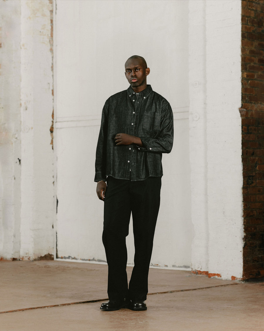 A man in a denim button down and black jeans.