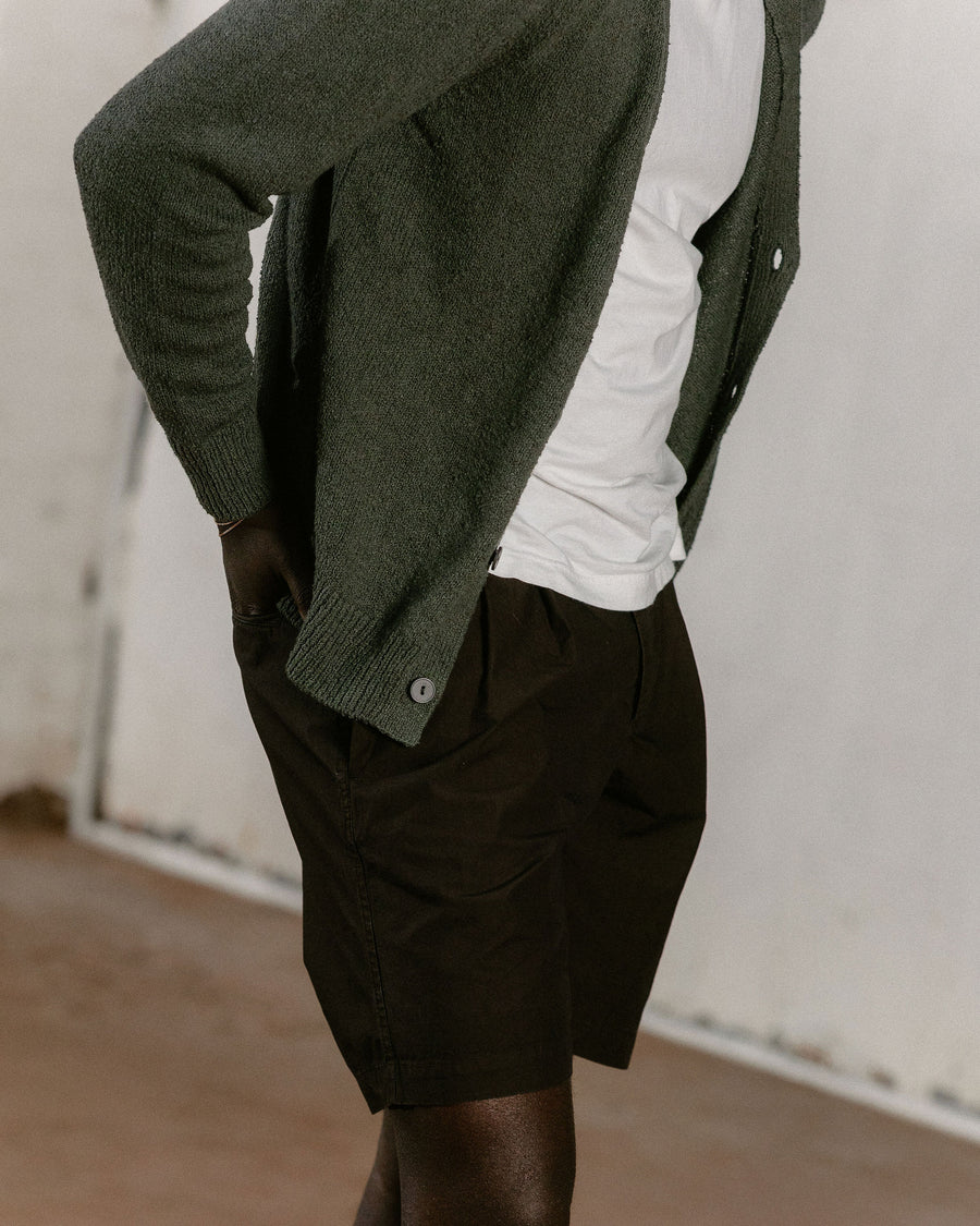 A close up on the texture of the olive cardigan and brown shorts.