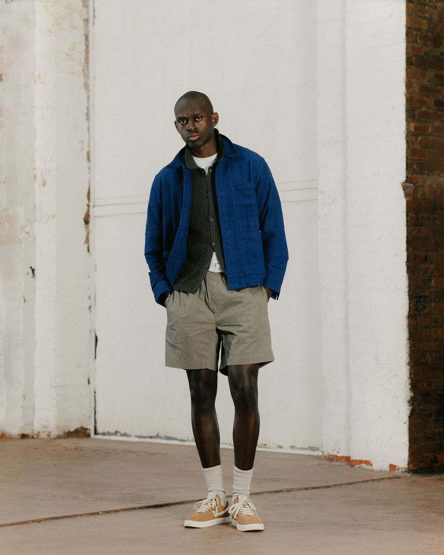 A man in an indigo blue jacket and tan shorts.