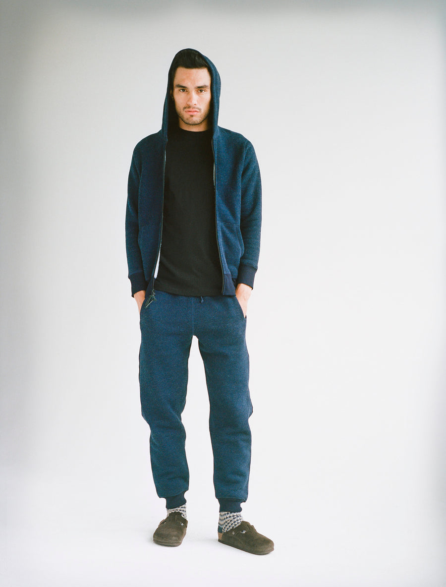 Model wearing indigo hoody and sweatpants along with a black tee