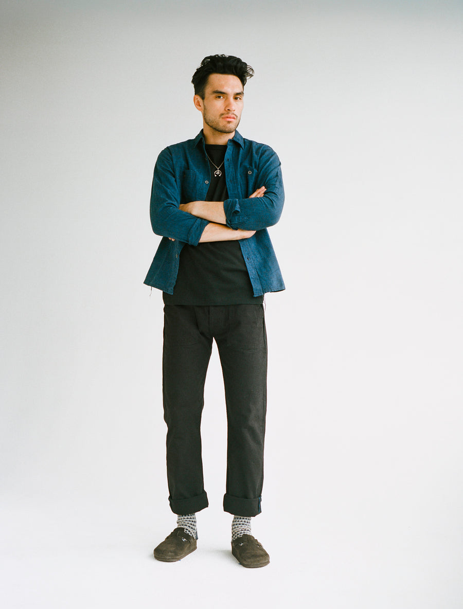 Model wears a navy chambray and black fatigue pants.