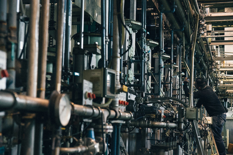 Man inspecting denim production machinery.