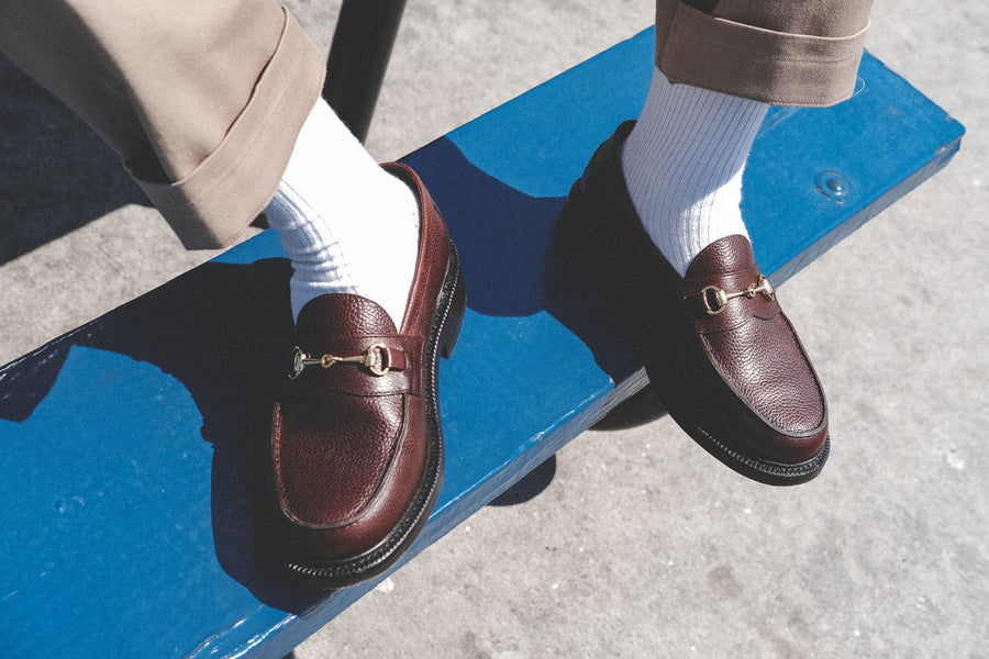 A pair of horse bit brown loafers in brown pebble grain.