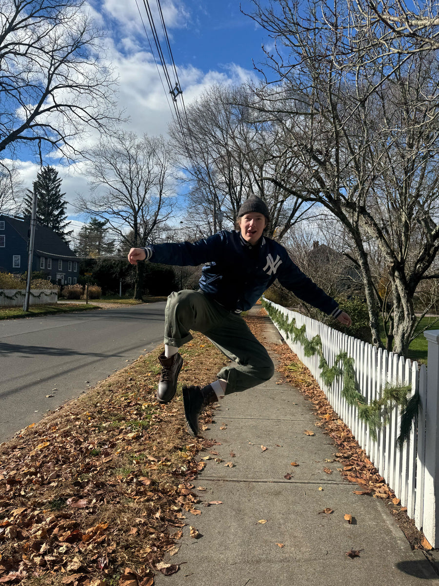 A man claps his heels in the street