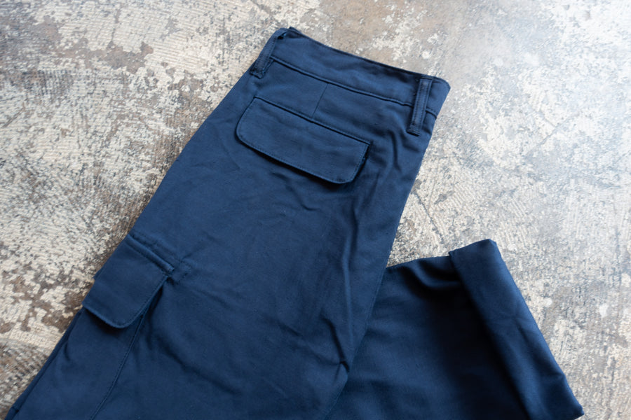 A pair of Navy Cargo pants lay folded on the floor.