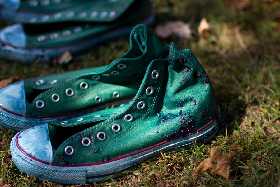 Green Converse sneakers are left to dry and oxidize on a lawn.