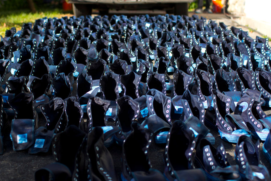 A wide angle shot of all the indigo dyed Converse sneakers drying on a driveway.