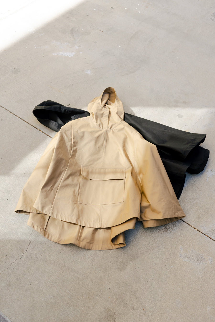 Two ponchos laying on the ground
