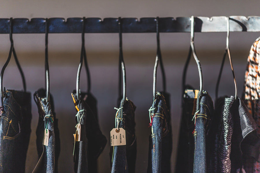 Close up of jeans hanging on display rack.