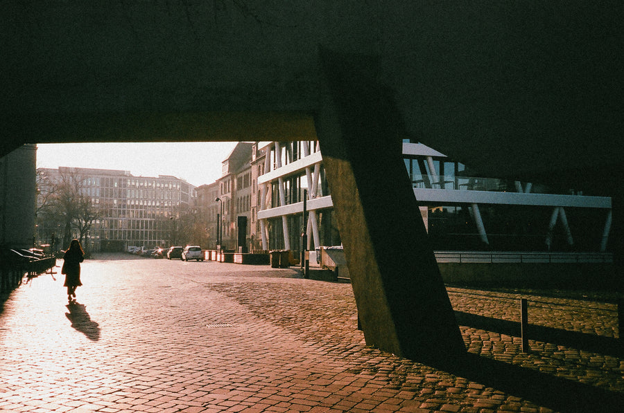 The sun sets on a brutalist building overpass in Berlin.