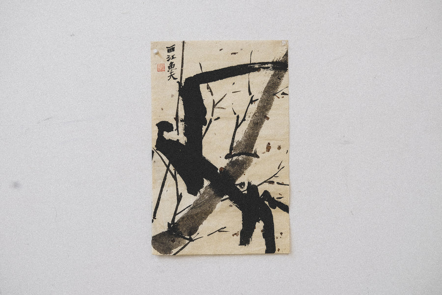 A piece of asian art pinned to a wall.