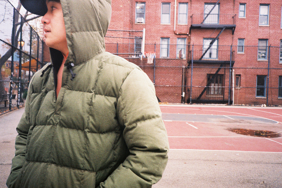 The model looks off in the distance with hood on the jacket raised.