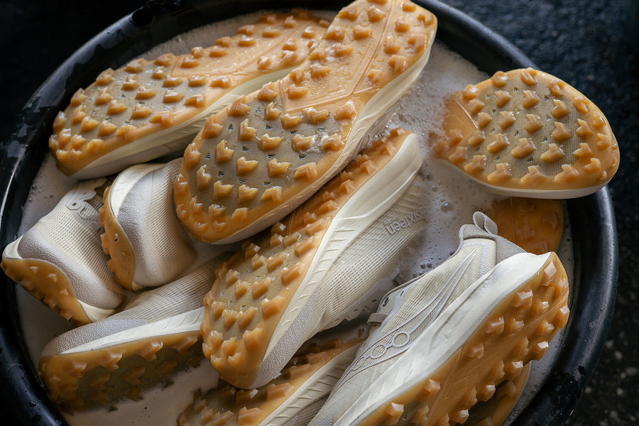 A bucket of white sneakers soaking in water