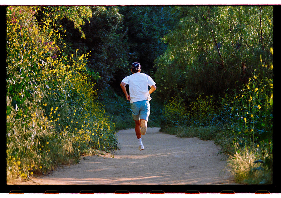 A man runs down a dirt trail.