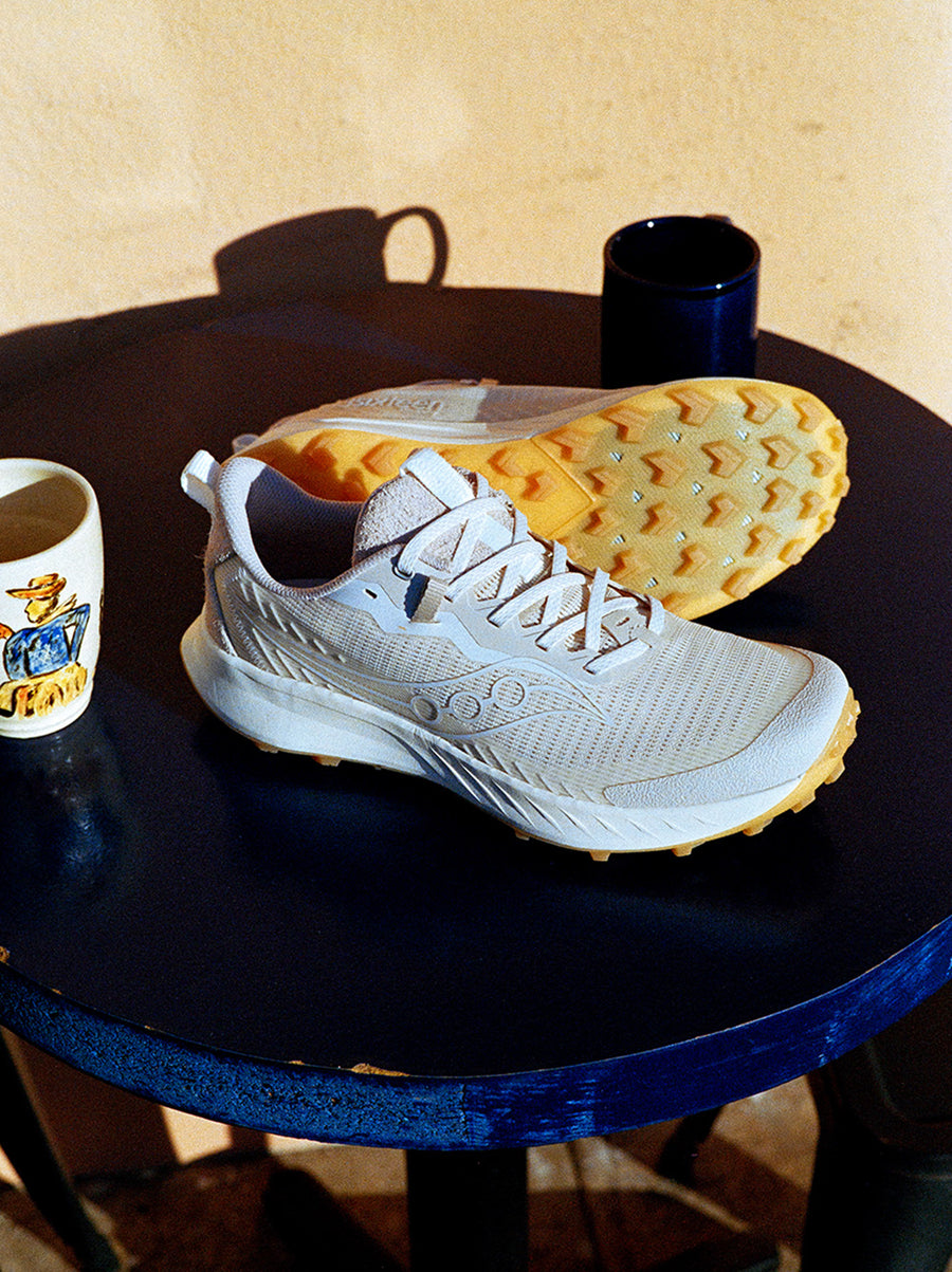 A pair of white sneakers on a blue table top.