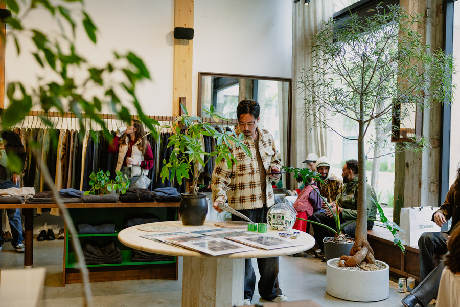 A man looking at some knick knacks on a table.