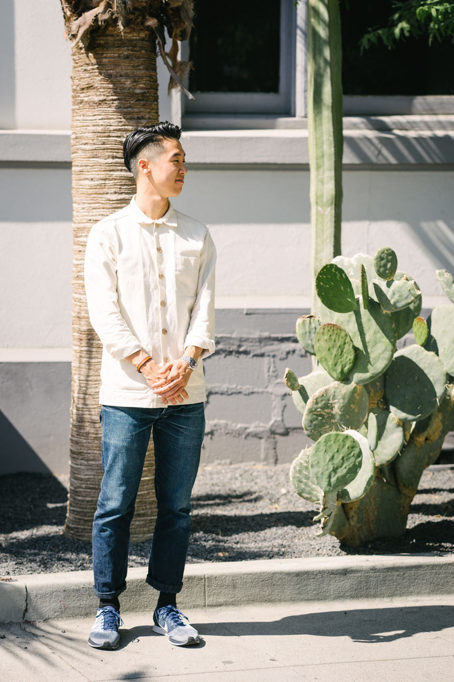 Joe poses with arms crossed in front of his body as he looks left.