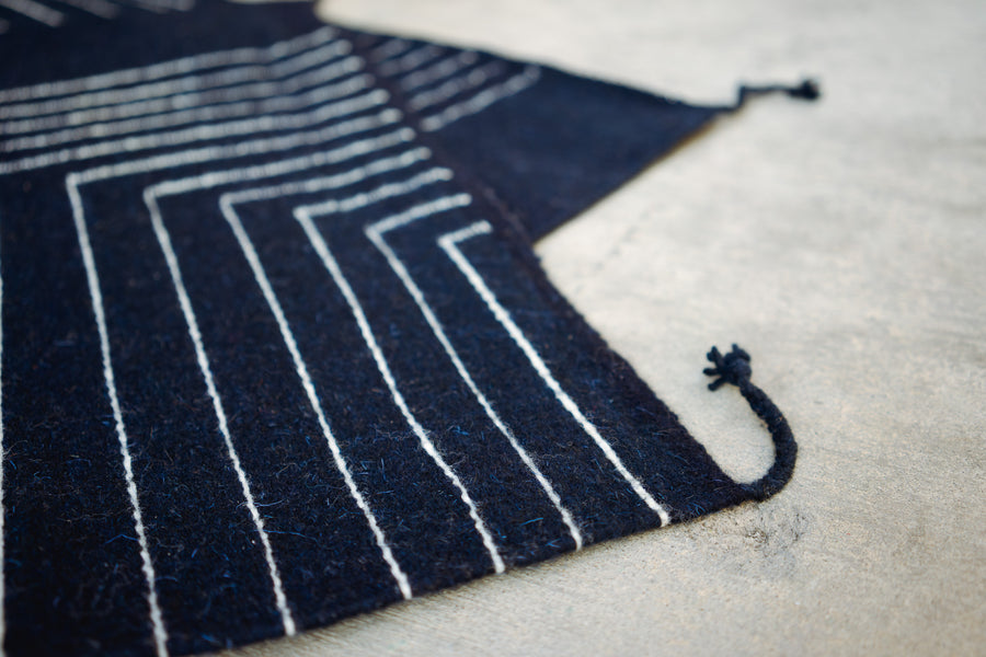 An up close detail shot of the indigo rug and its detailed white stripes.