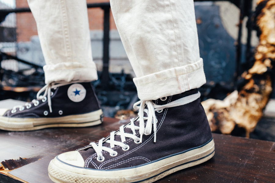 A closeup shot of the redline selvedge detail on the cuffs of the natural chinos.
