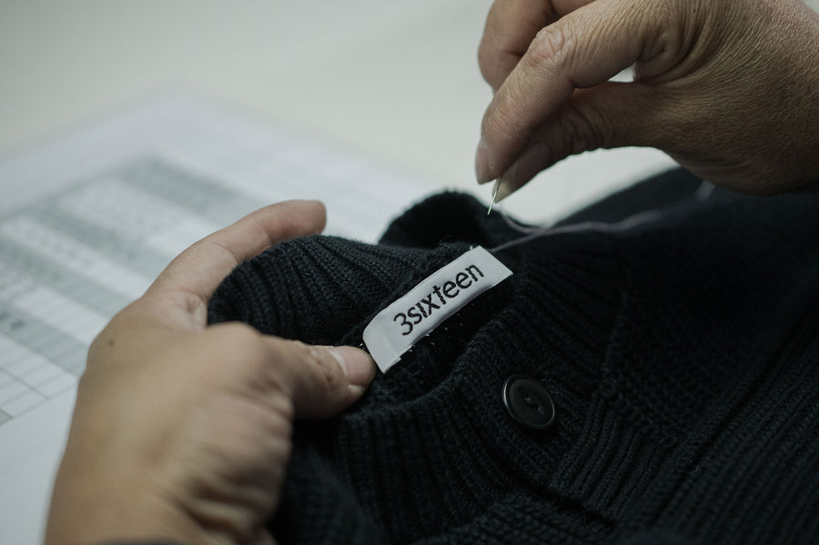 A woven label is sewn into a sweater neck.