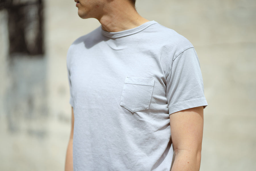 A close-up shot of the ash garment dyed pocket tee on a model.