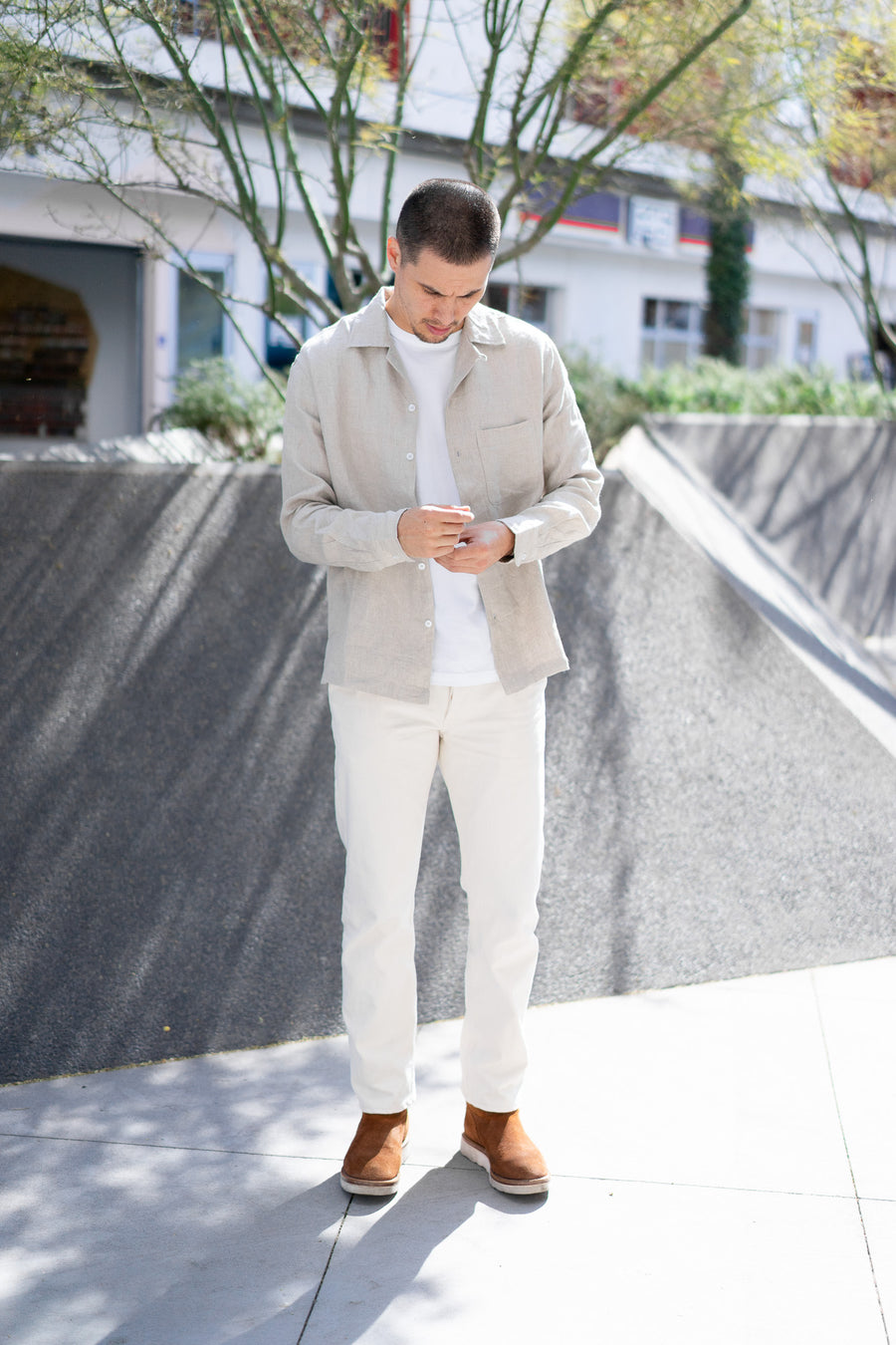 A man wears a linen shirt and natural colored chinos.