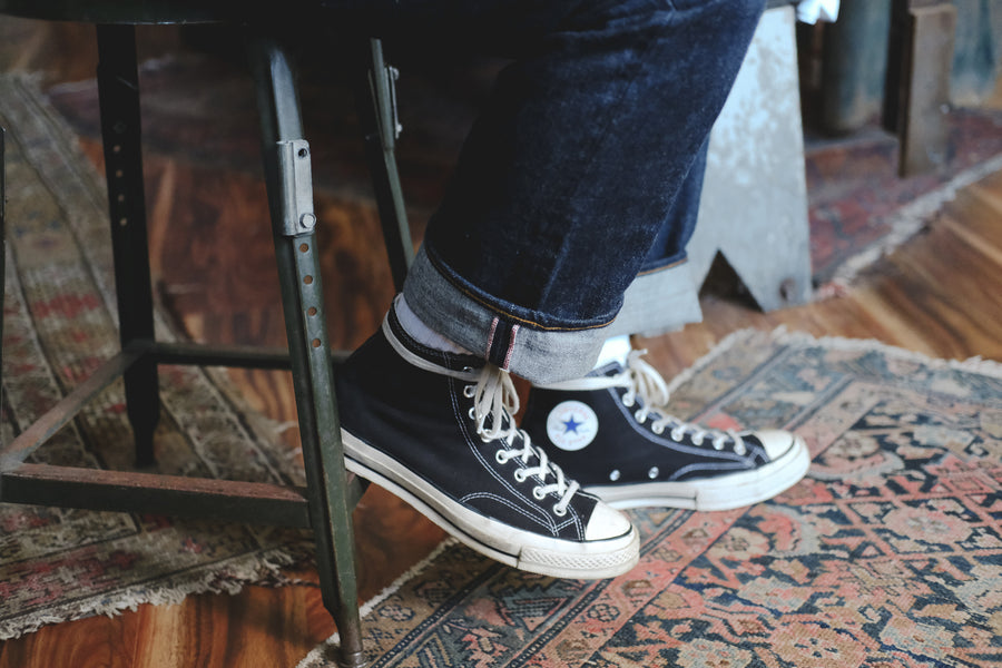 A close up photo of our CS jeans with chuck taylor sneakers.
