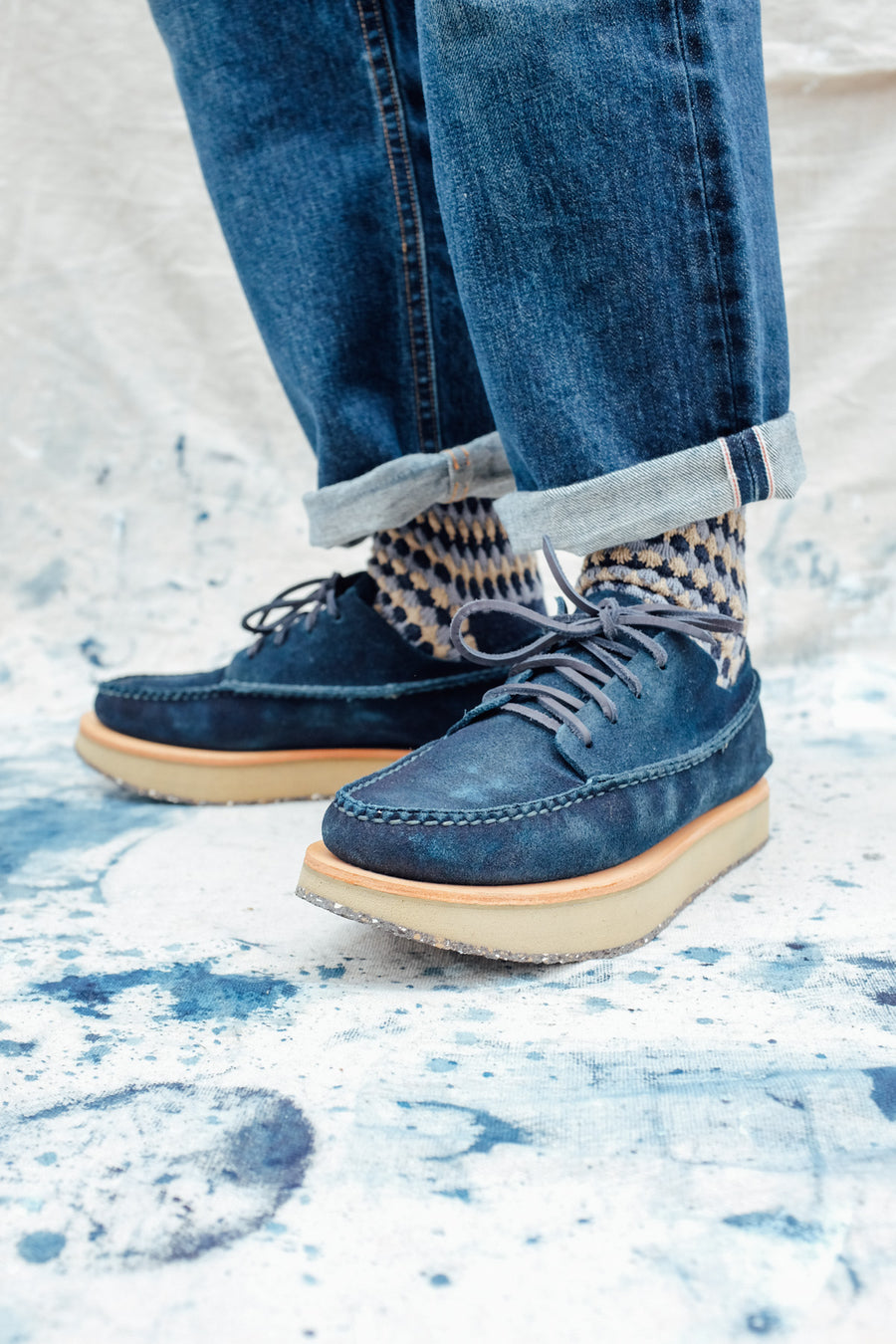 A final front oblique shot of the indigo moccasins worn on feet.