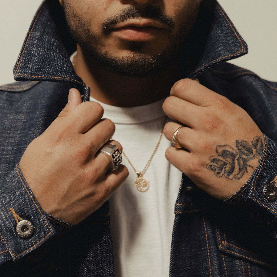 A portrait of a man in a denim jacket.