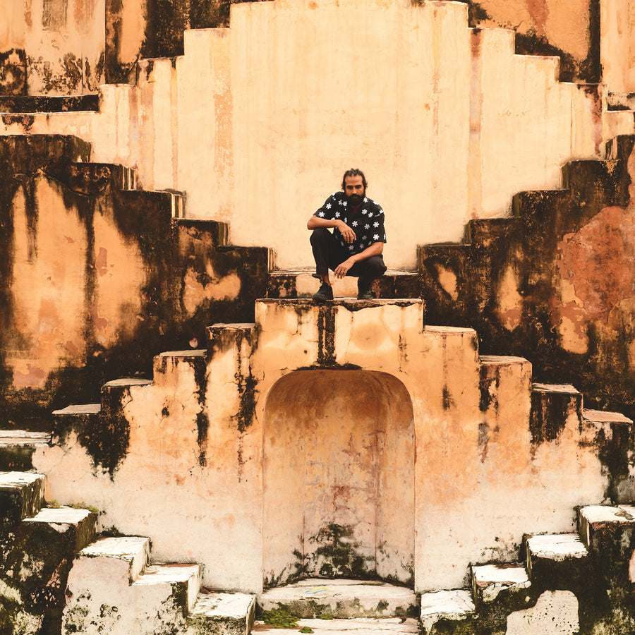 A man crouches in a staircase.