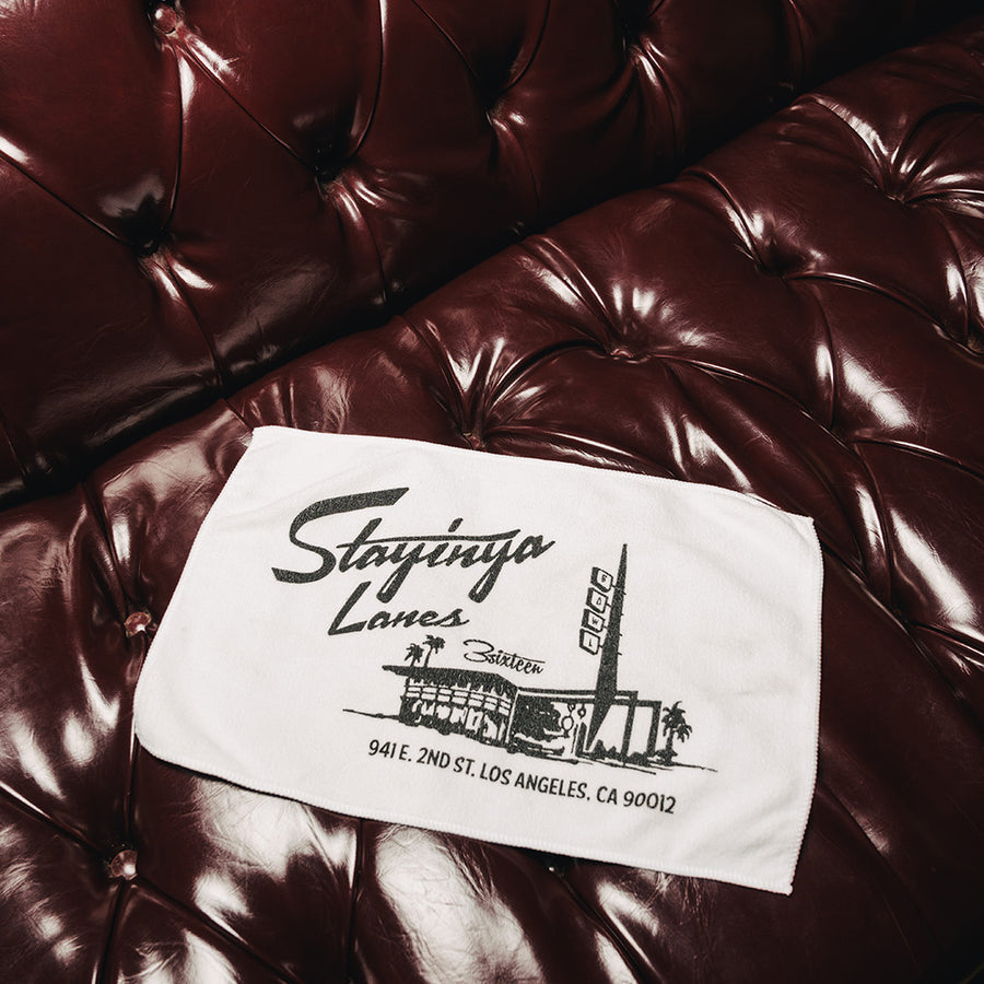 A white bowling towel sits on a couch.