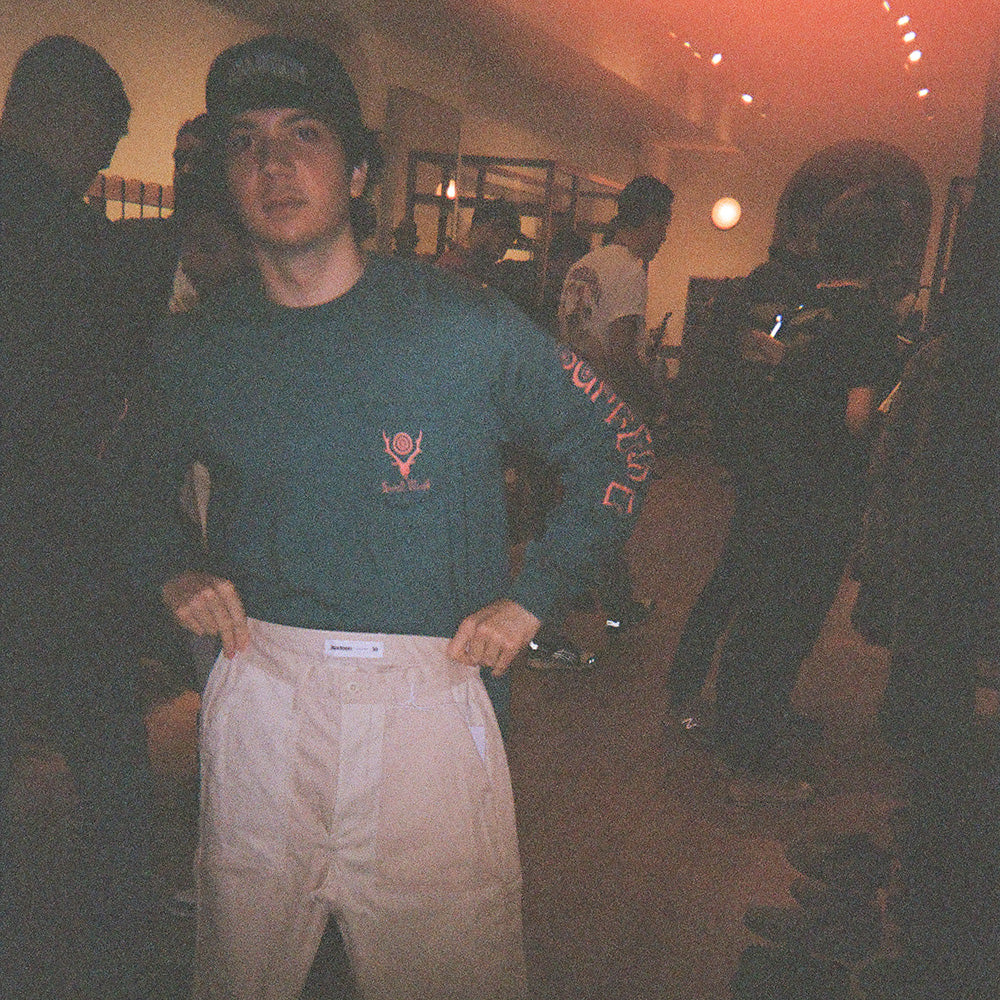 A young man holds up a pair of the podcast pants.