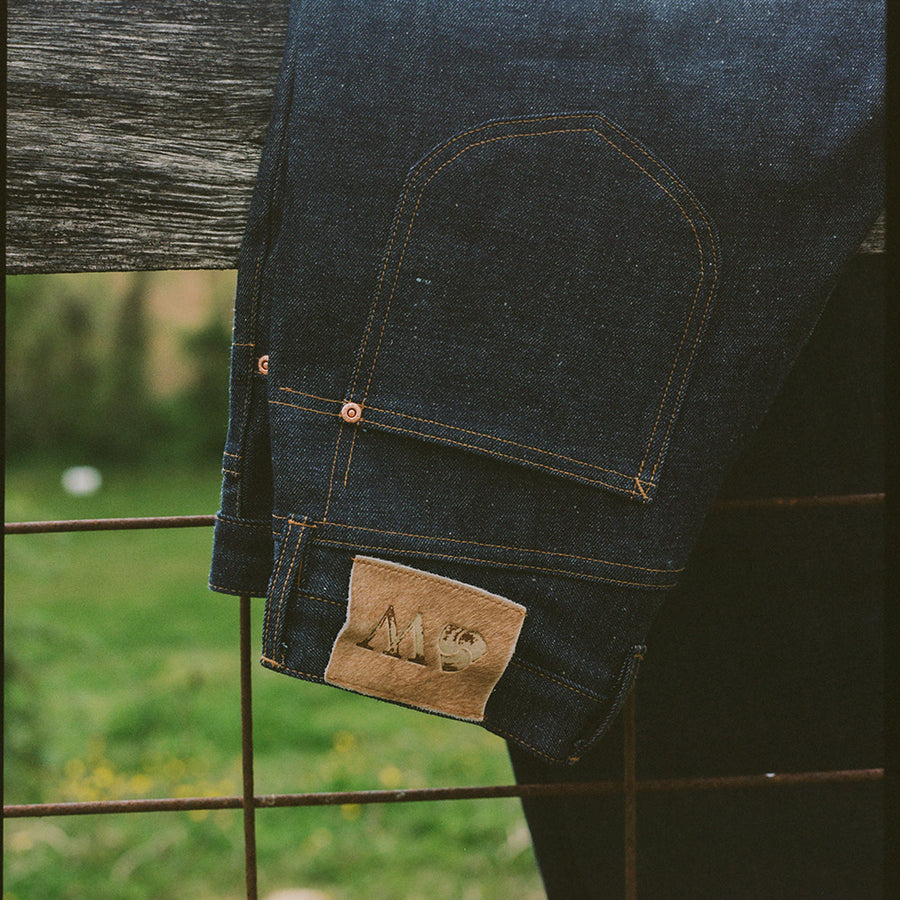A pair of jeans on a fence.
